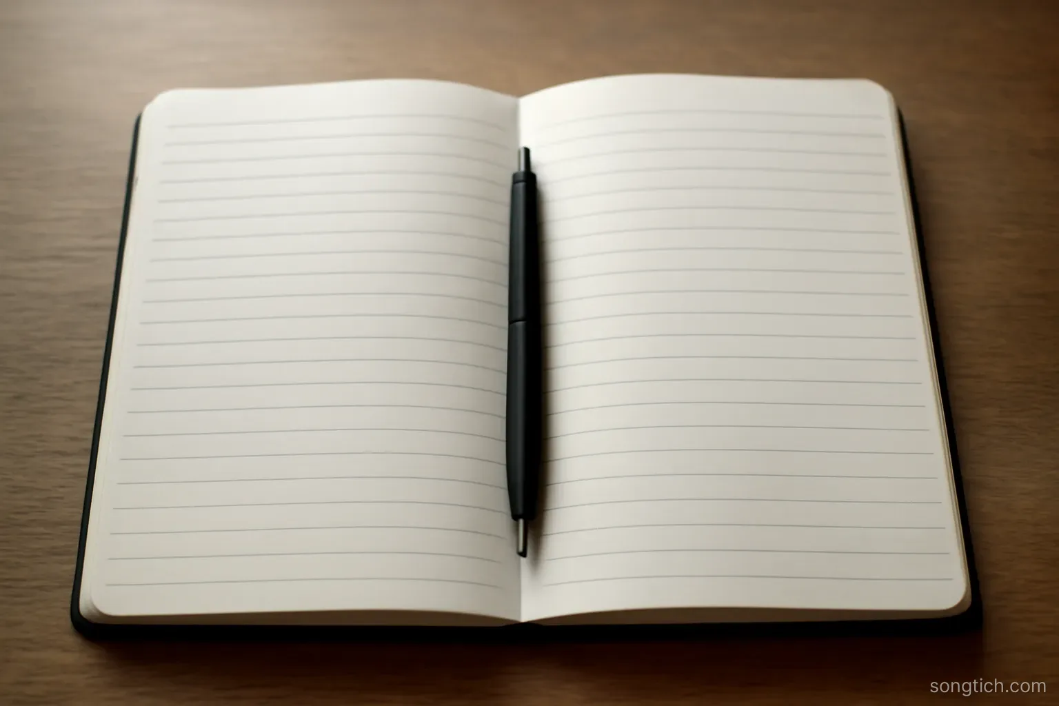 a ruled notebook lying open at a blank double page with a pen resting in the crease, overhead view